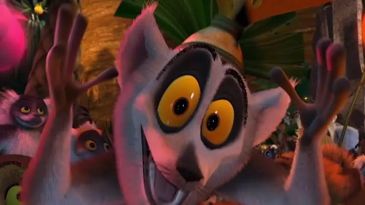 King Julien waving his hands in front of a crowd of lemurs