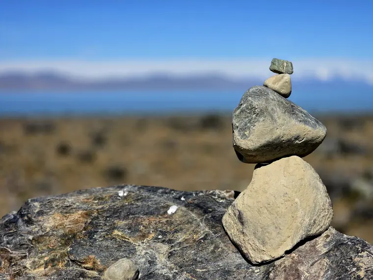 Stacked stones with a lake behind