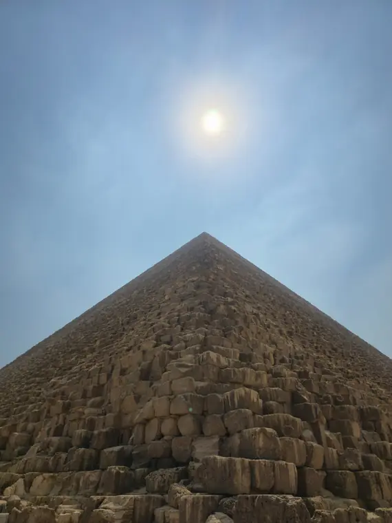 The Great Pyramid rising toward a hazy sun