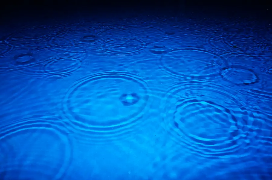 Rain falling on bright blue water